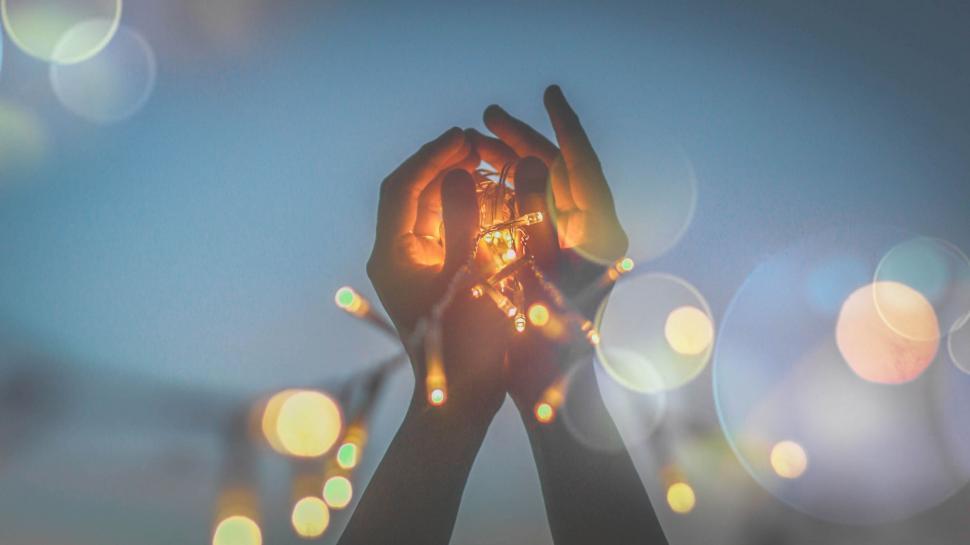 Free Image of Hands holding a string of lights 