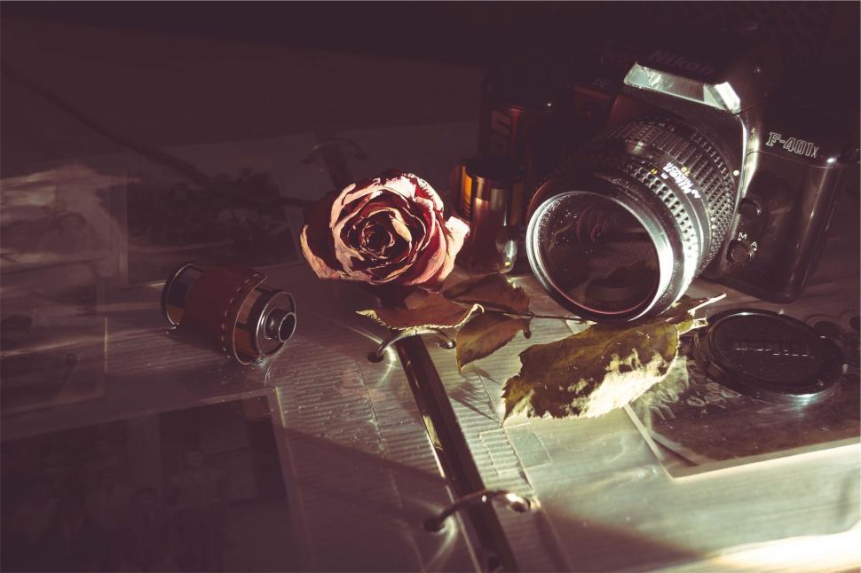 Free Image of A camera and a rose on a table 