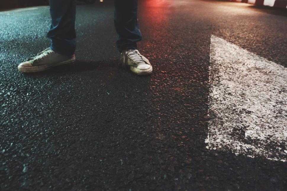 Free Image of A person s legs and shoes on a street 