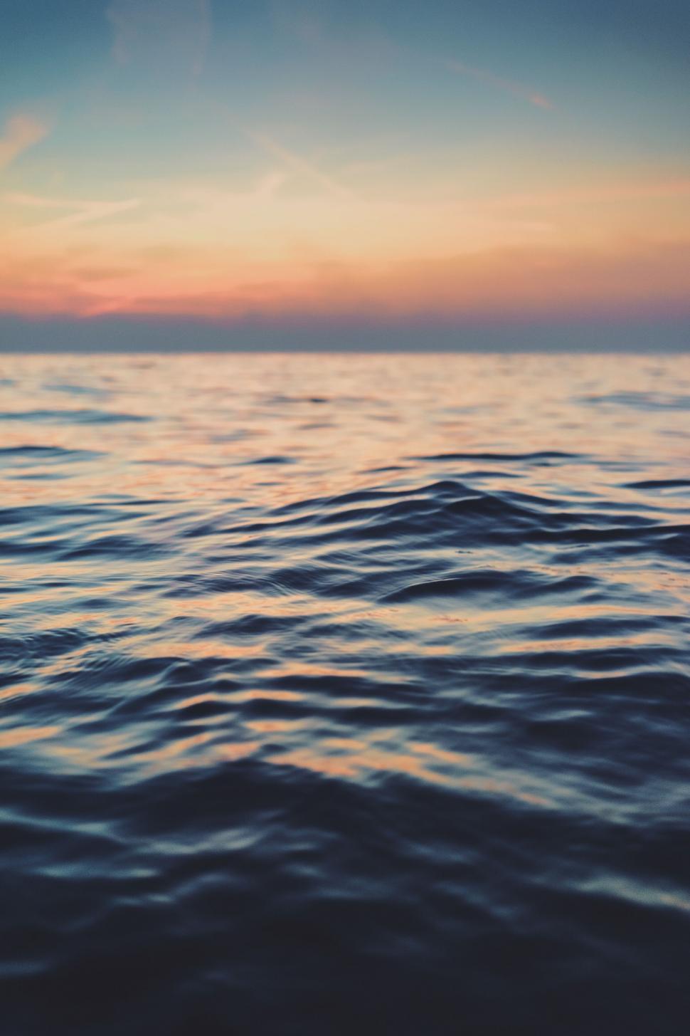 Free Image of A body of water with a sunset in the background 