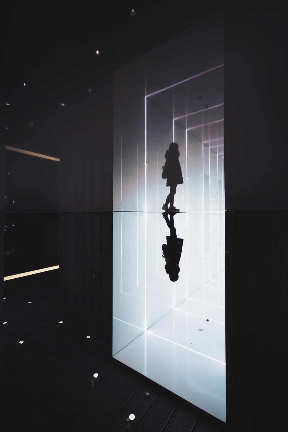 Free Image of A person standing in a room with a mirror 