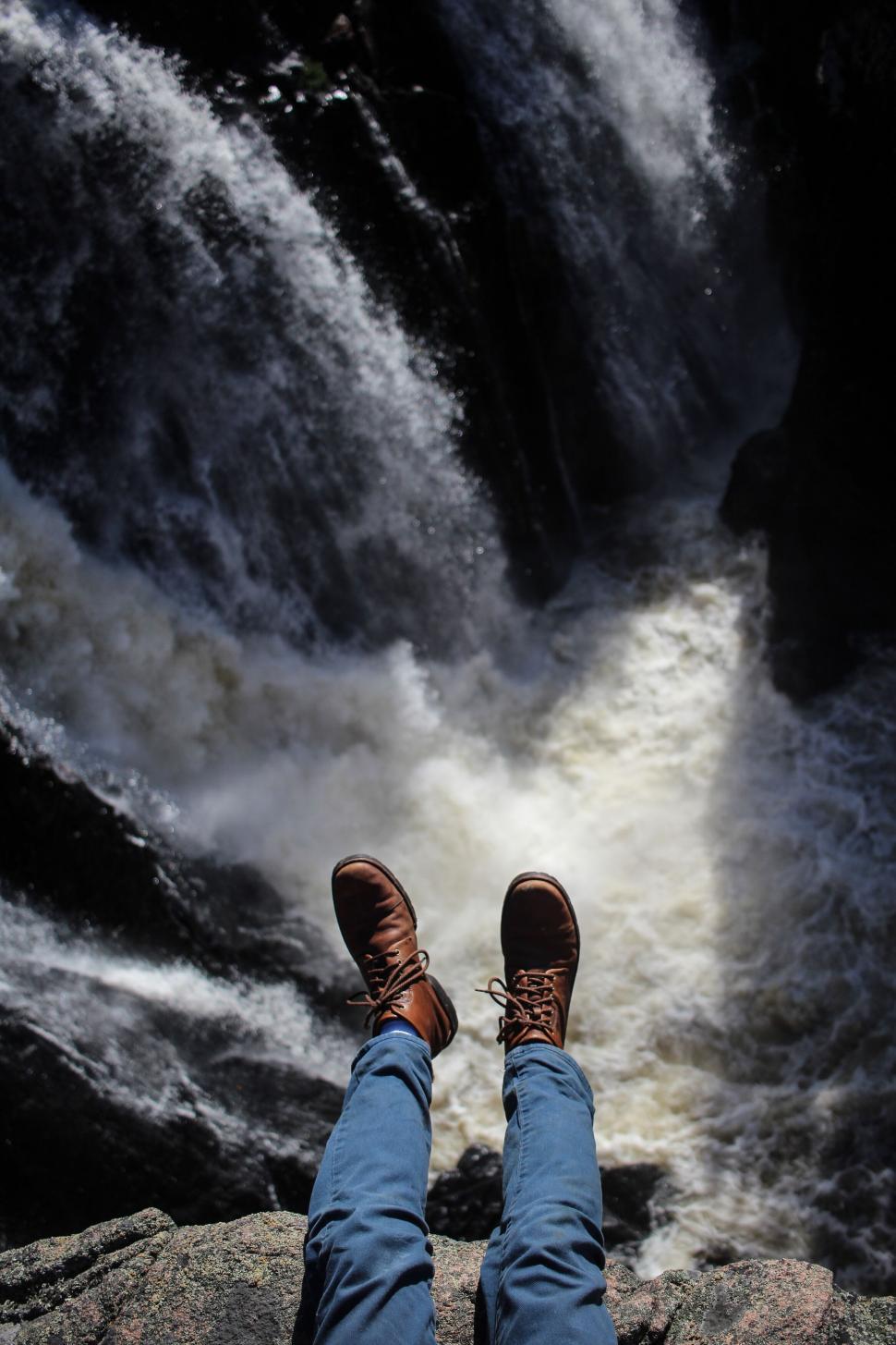 Free Image of A person s legs and feet above a waterfall 