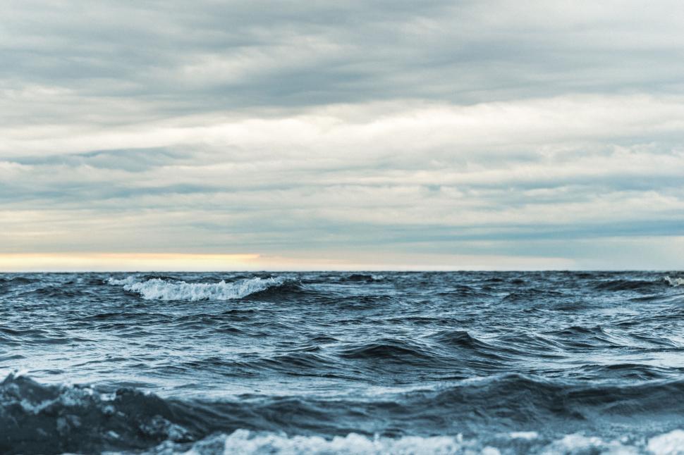 Free Image of Waves in the ocean with clouds in the sky 