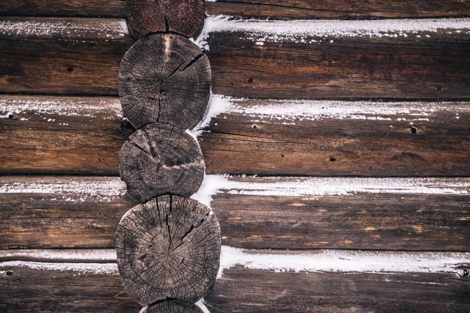 Free Image of A row of wood logs with snow on them 