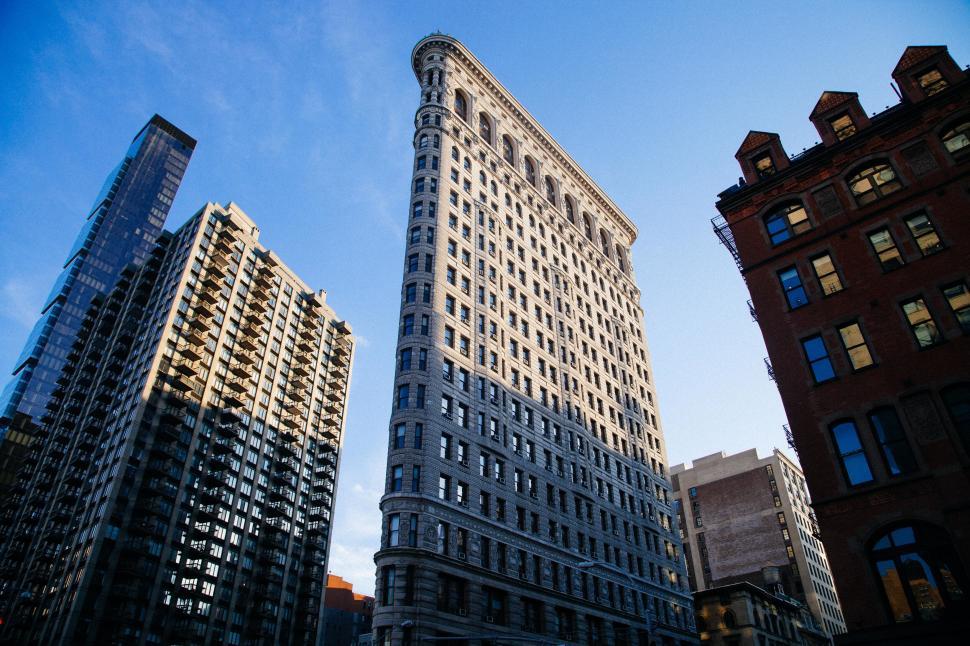 Free Image of A tall building with many windows with flatiron building in the background 