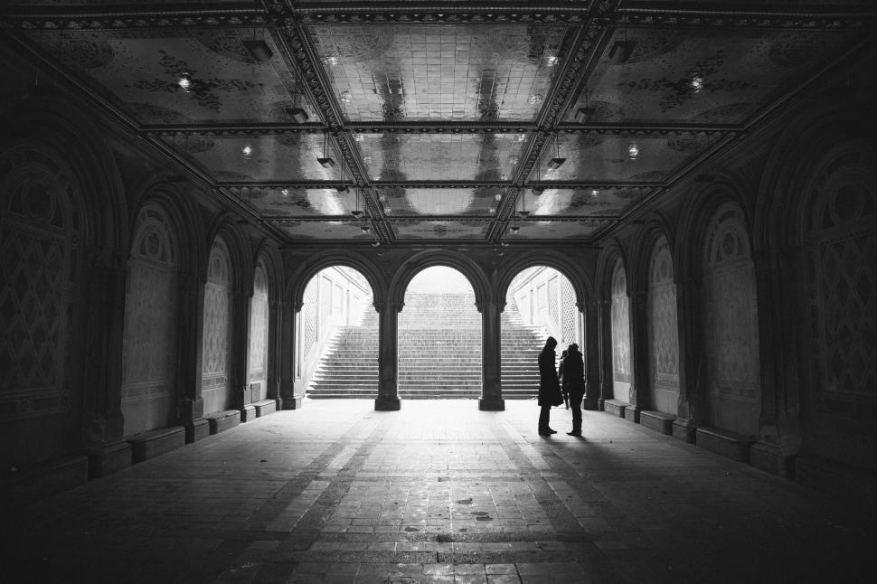 Free Image of A couple of people standing in a hallway 