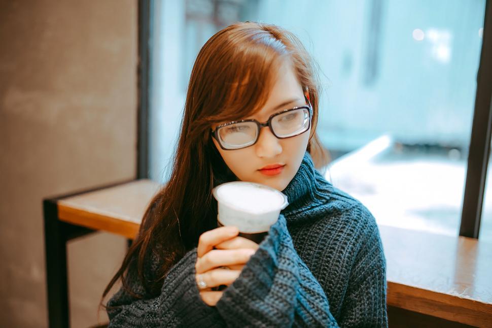 Free Image of A woman holding a cup of coffee 