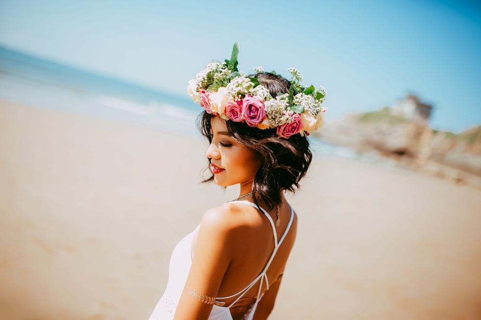 Free Image of A woman wearing a flower crown on a beach 