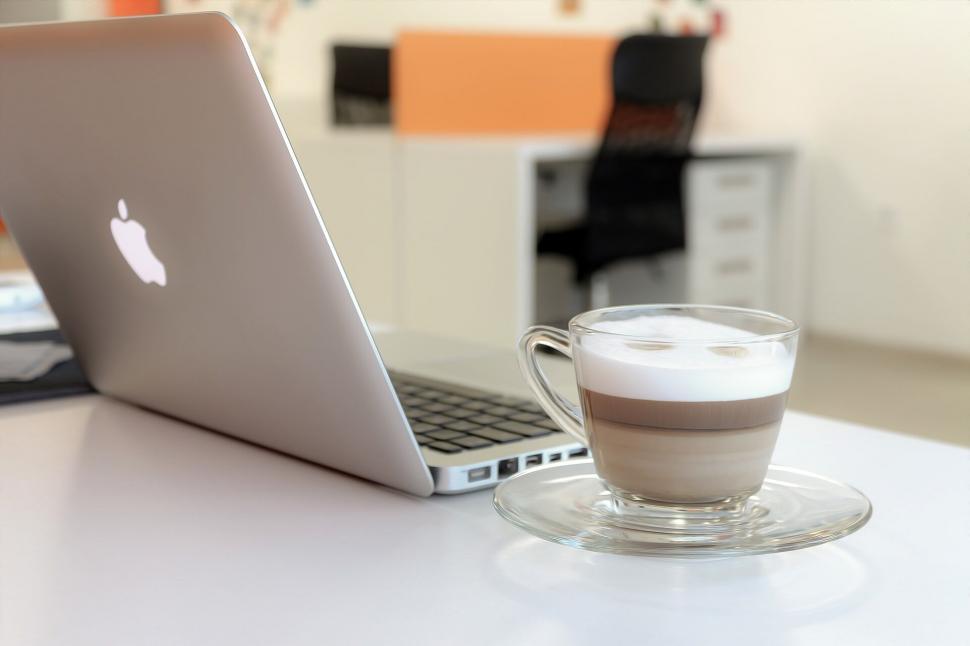 Free Image of A cup of coffee and a laptop on a table 