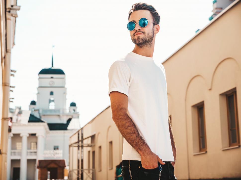 Free Image of A man wearing sunglasses and a white shirt 