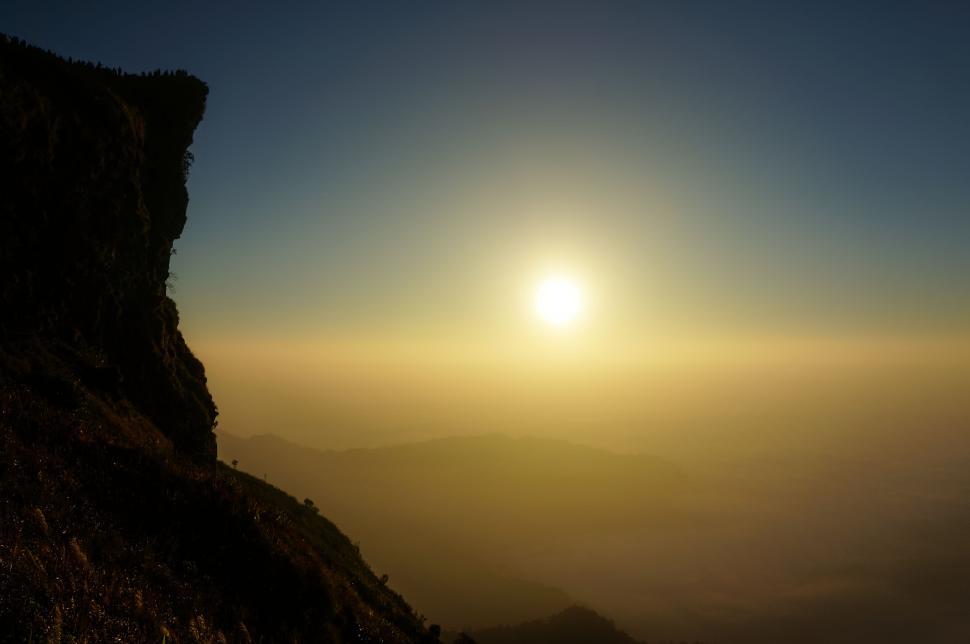 Free Image of A sun setting over a mountain 