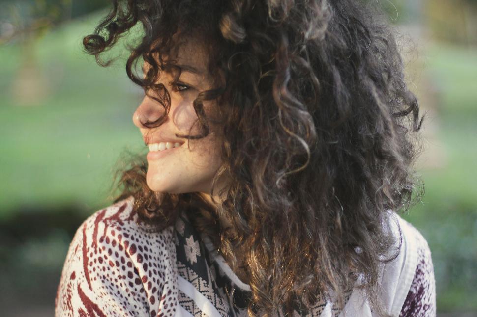 Free Image of A woman with curly hair smiling 