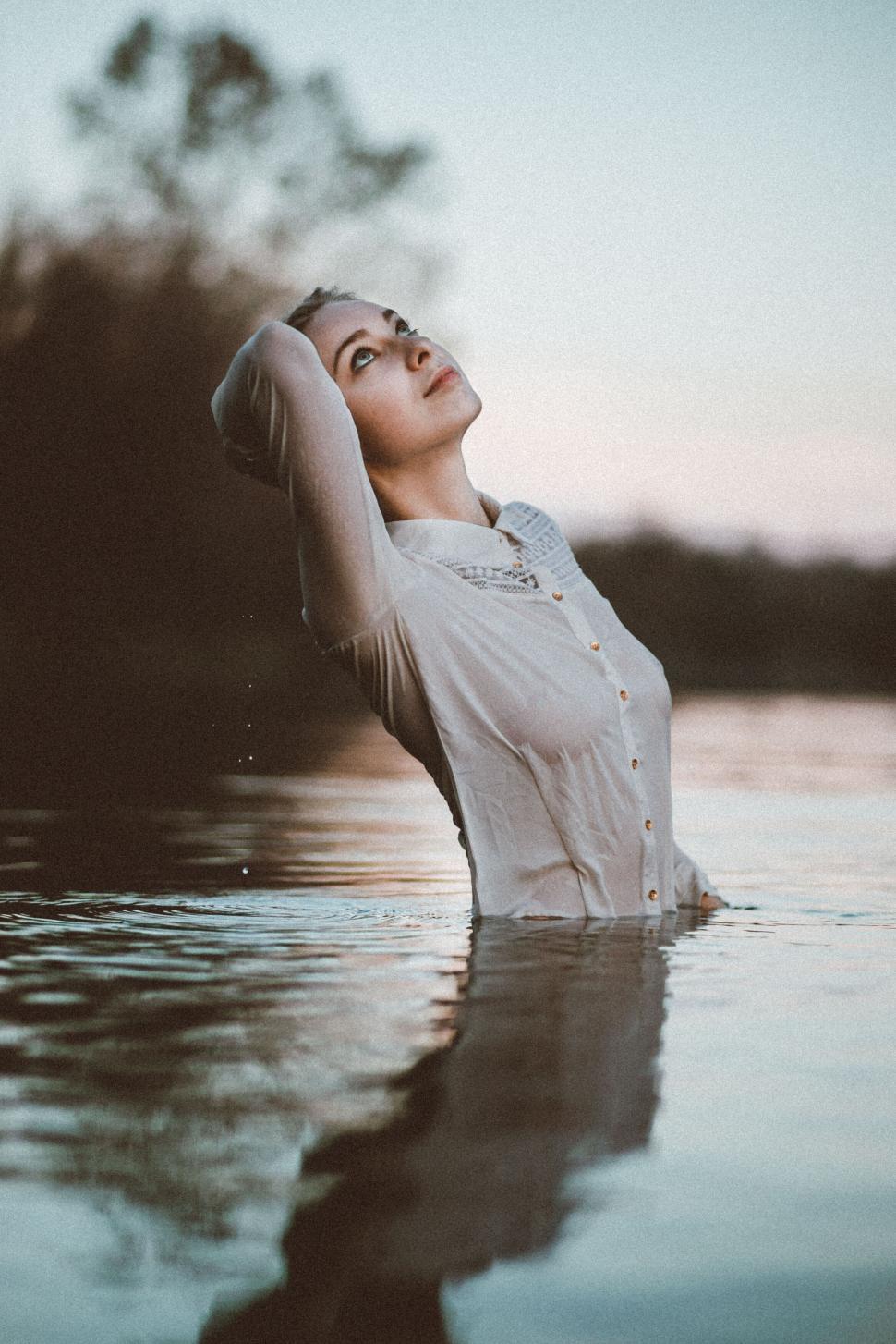 Free Image of A woman in a white shirt standing in water 