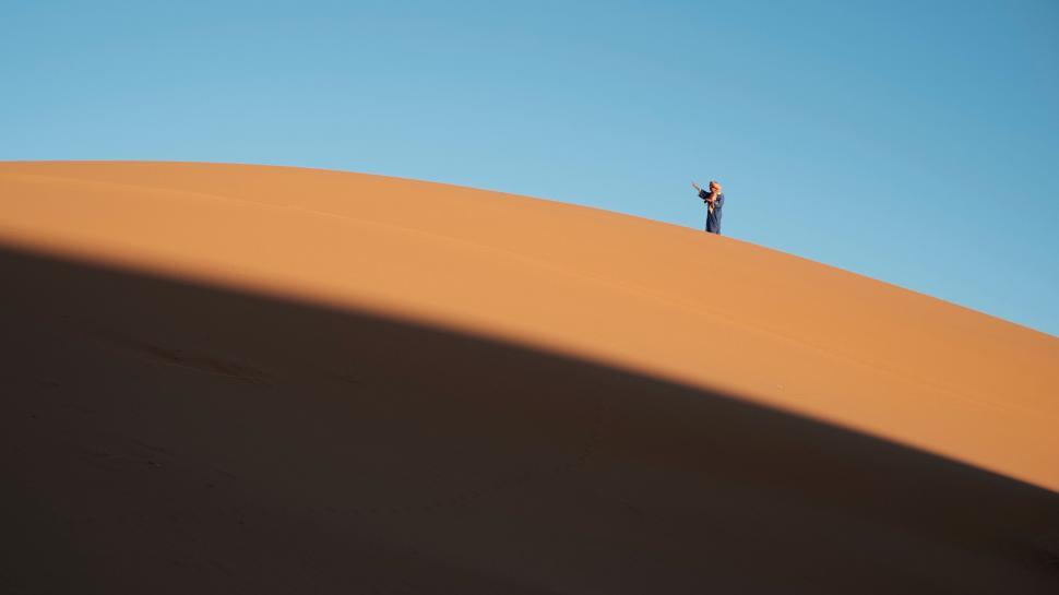 Free Image of A person standing on a sand dune 