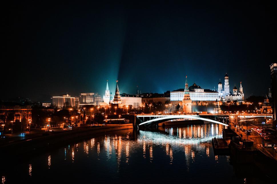 Free Image of A bridge over a river with a city at night 