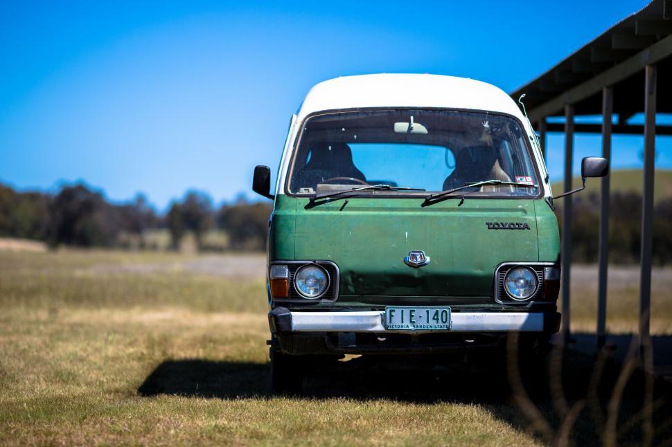 Free Image of A green van parked in a field 