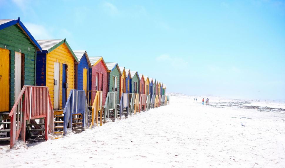 Free Image of A row of colorful huts on a beach 