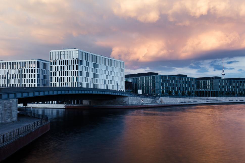 Free Image of Harpa over water with buildings and clouds in the sky 