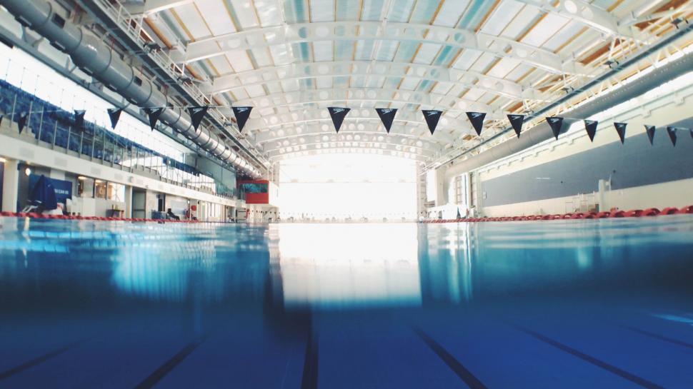 Free Image of A swimming pool with a large building and a large ceiling 
