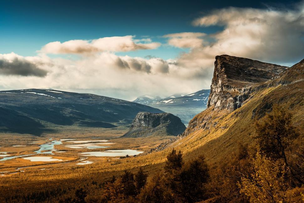 Free Image of A landscape of a valley with a river and mountains 