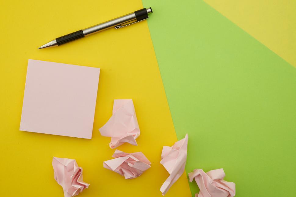 Free Image of A pen and paper on a yellow and green surface 