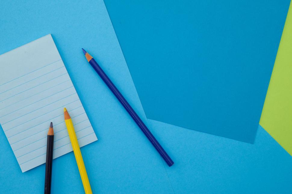 Free Image of A group of colored pencils on a blue background 