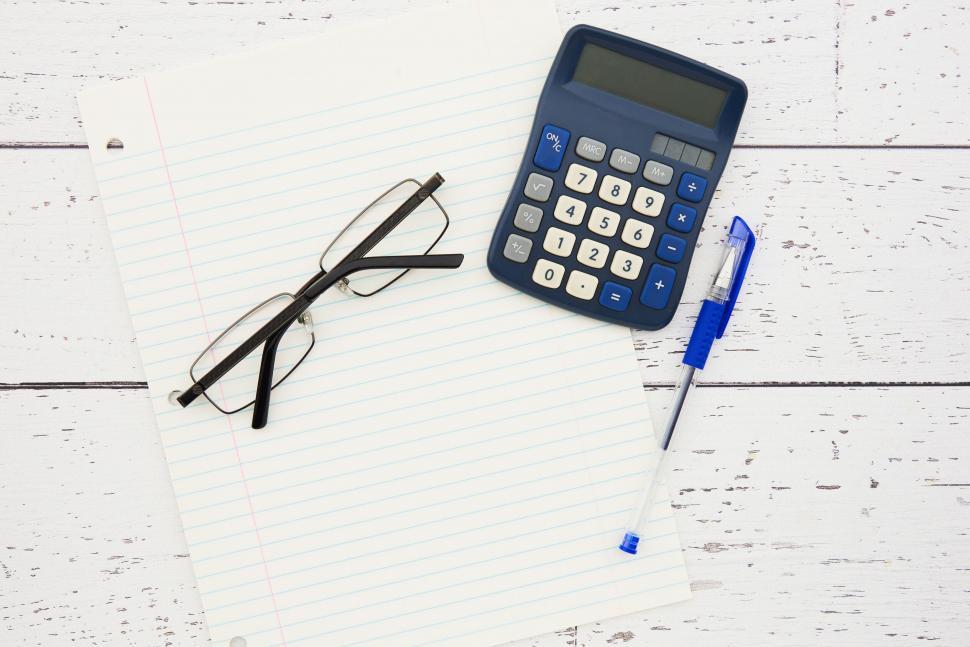 Free Image of A calculator and pen on a piece of paper 