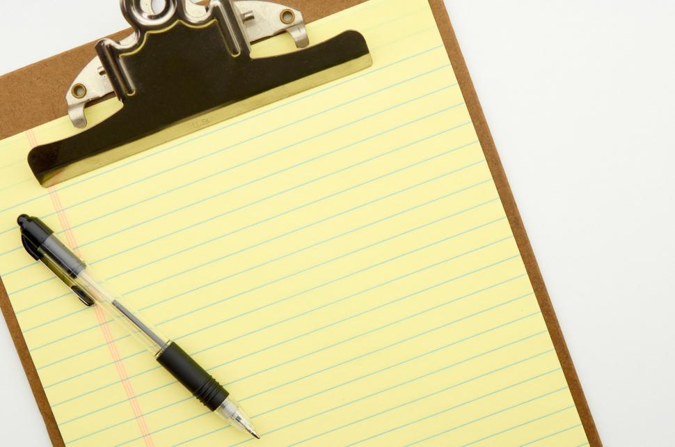 Free Image of A clipboard with yellow lined paper and a pen 