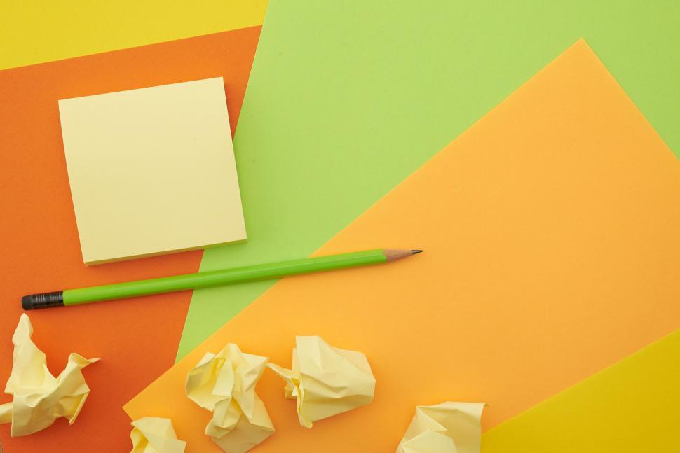 Free Image of A pencil and sticky notes on a colorful surface 