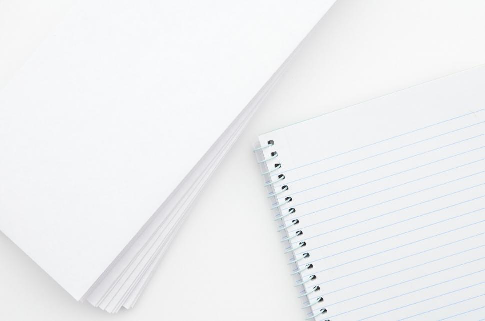 Free Image of A spiral notebook and a stack of papers 
