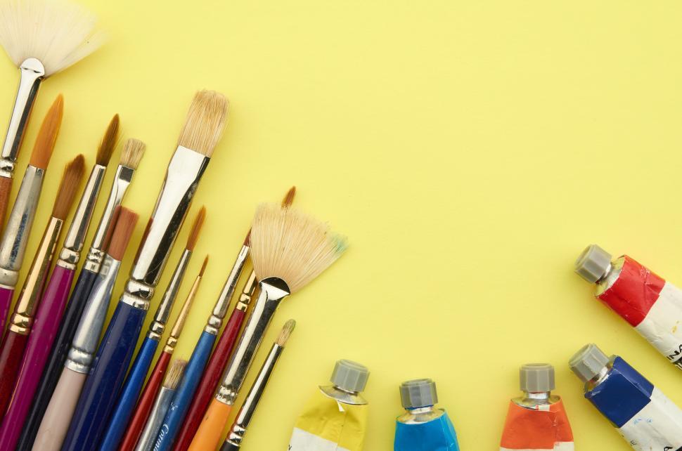 Free Image of A group of paint brushes and tubes of paint 