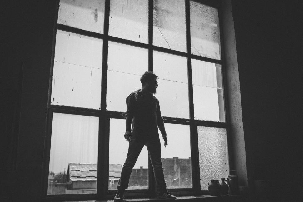 Free Image of A man standing in front of a window 