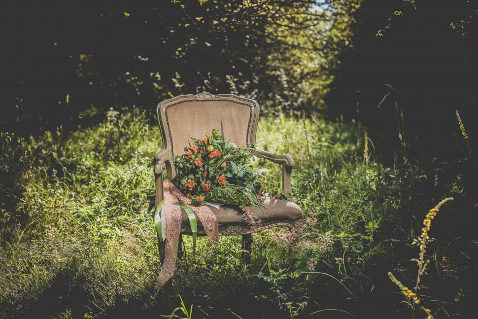 Free Image of A chair with flowers on it in the grass 