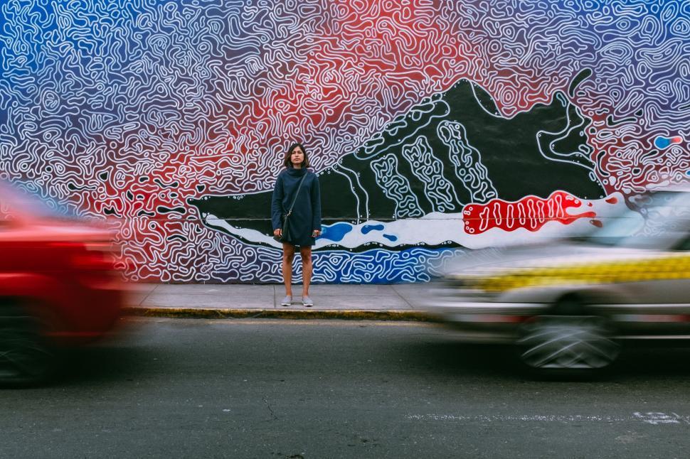 Free Image of A woman standing in front of a mural 