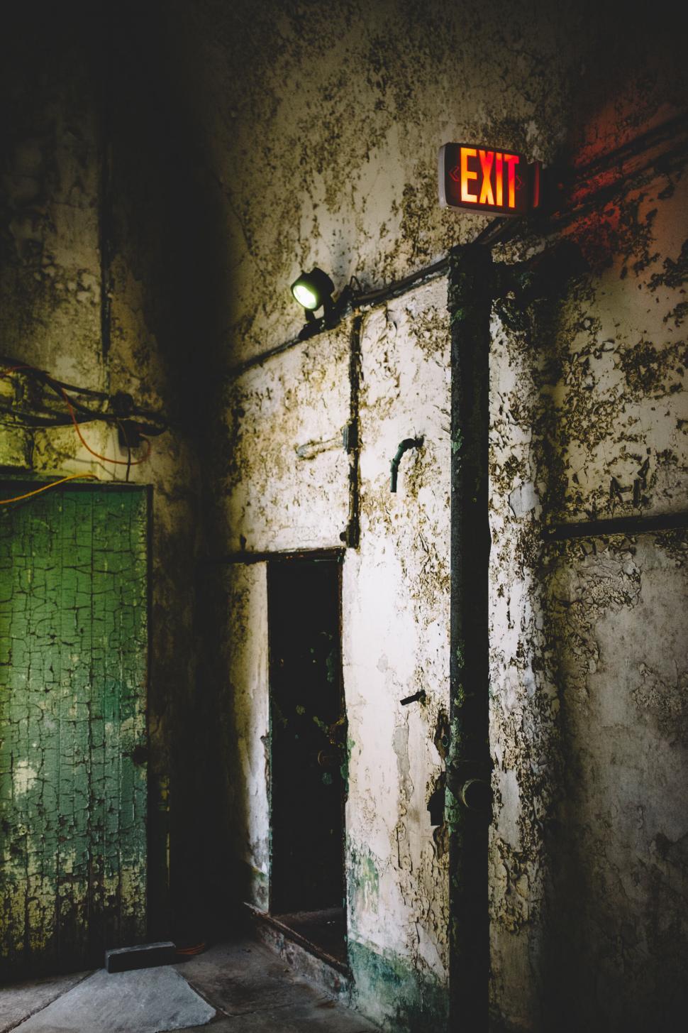 Free Image of A dirty room with a light and a green door 