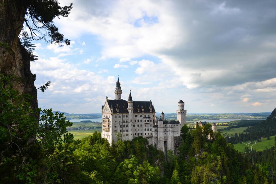 Free Image of A castle on a hill with neuschwanstein castle in the background 