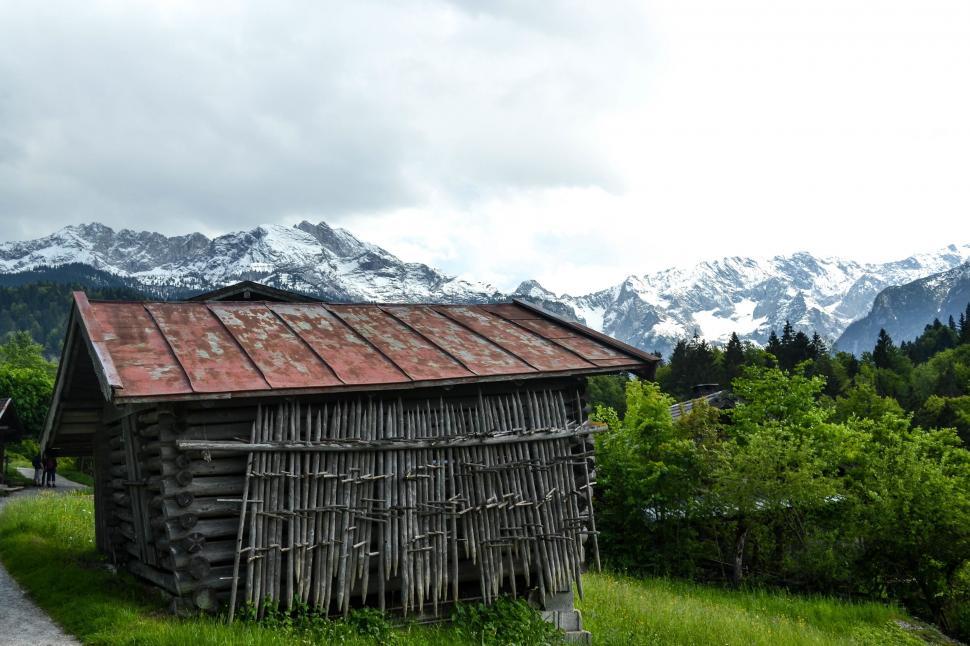 Free Image of A wooden building with a red roof and a snowy mountain in the background 