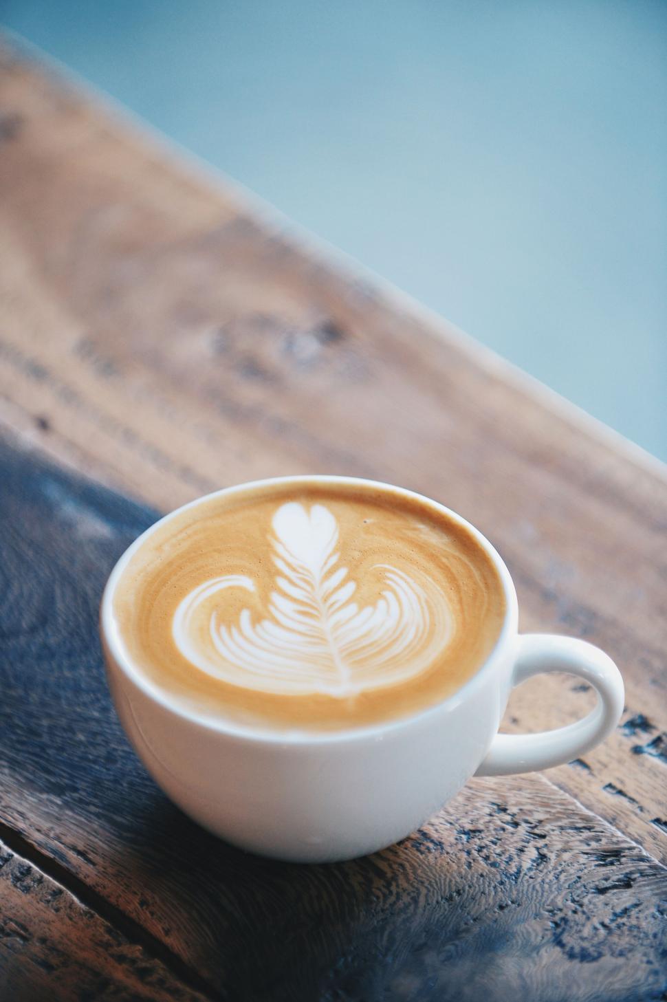 Free Image of A cup of coffee with a leaf design in the foam 