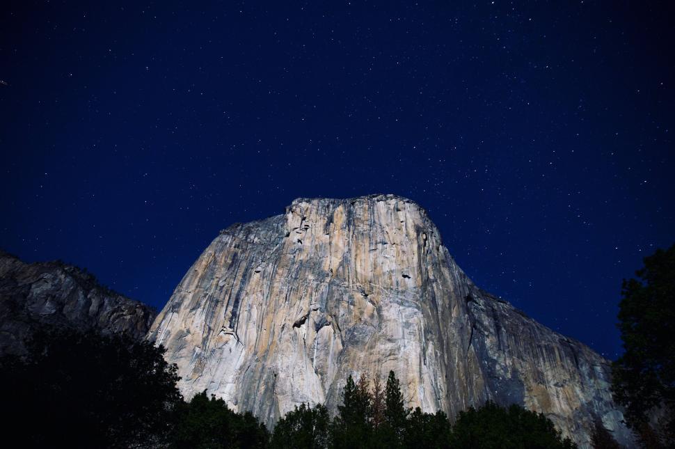 Free Image of A large rock mountain at night with el capitan in the background 