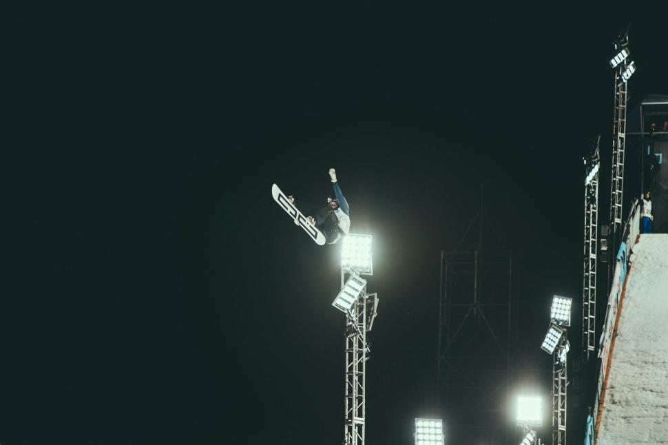 Free Image of A person on a snowboard jumping off a tower 