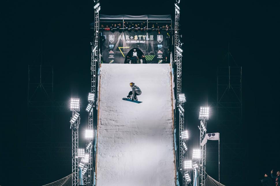 Free Image of A person on a snowboard going down a ramp 