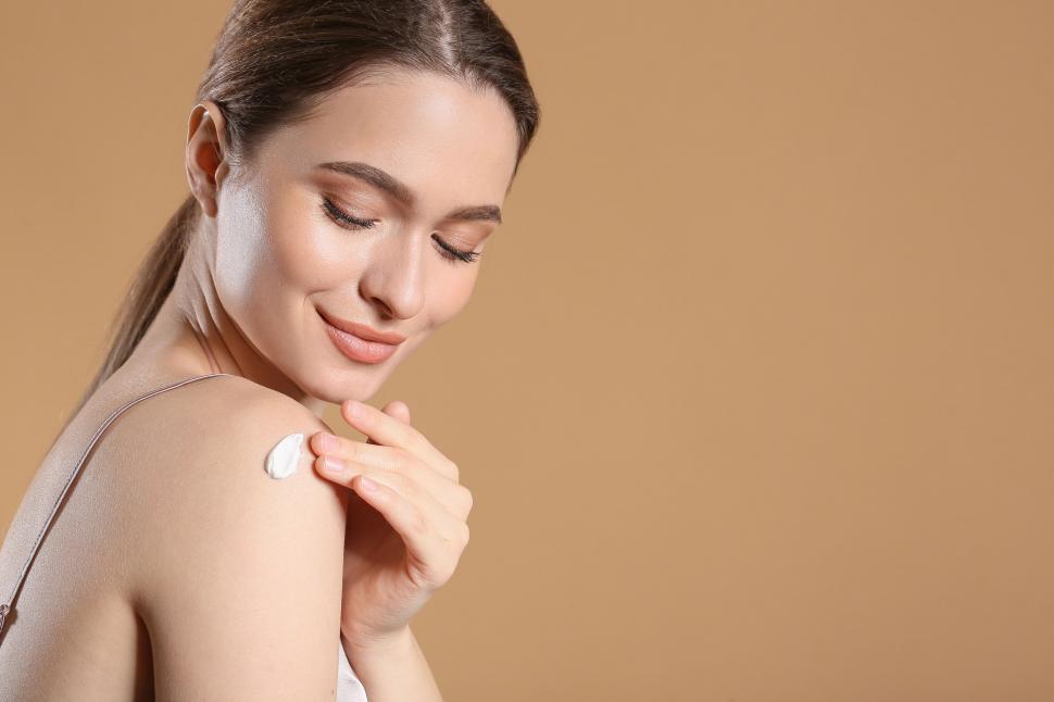 Free Image of A woman applying cream on her shoulder 