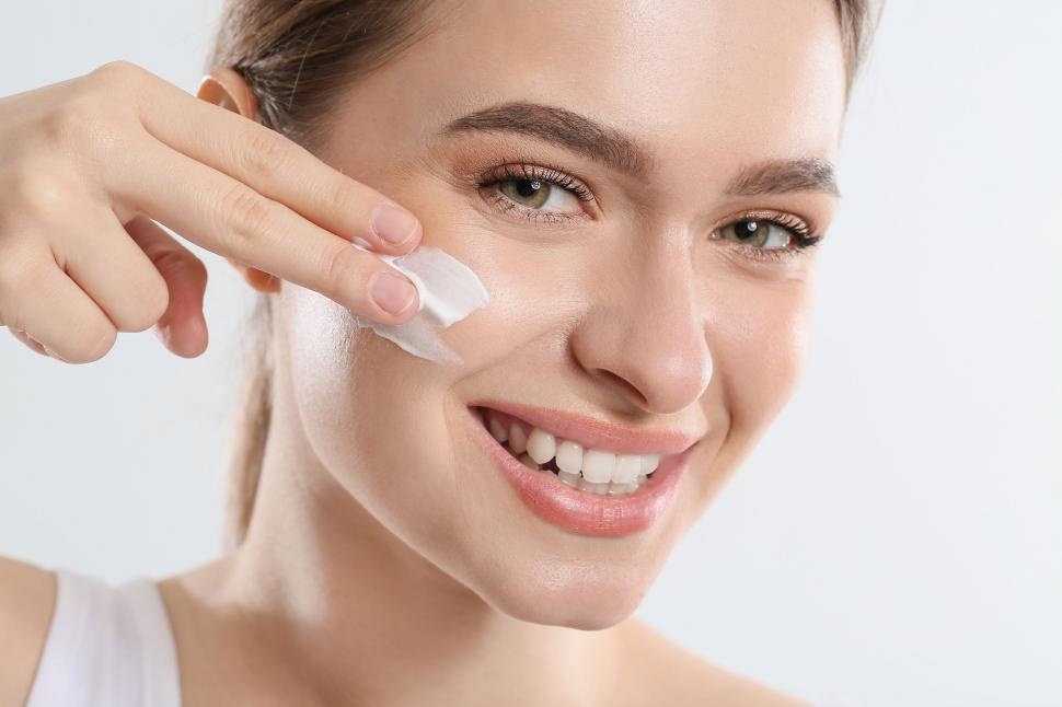 Free Image of A woman applying cream on her face 