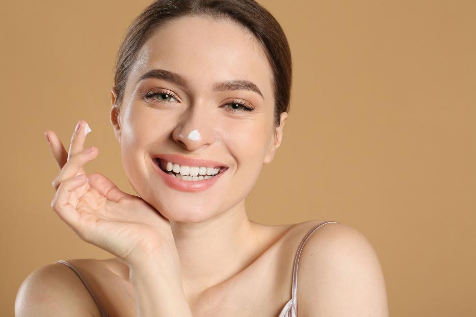Free Image of A woman smiling with cream on her face 