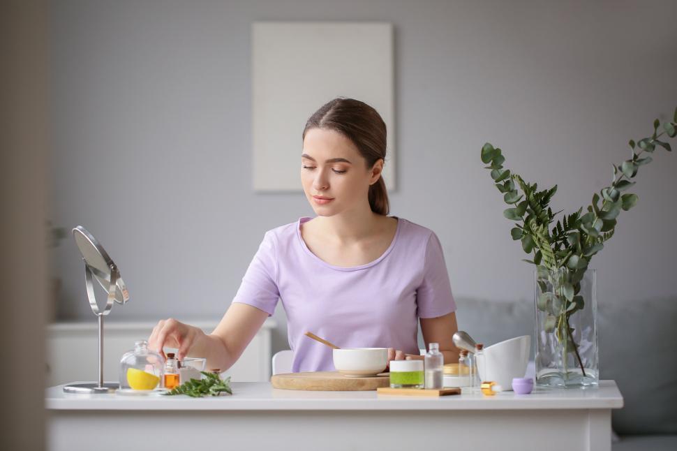 Free Image of A woman sitting at a table with a bowl of oil 