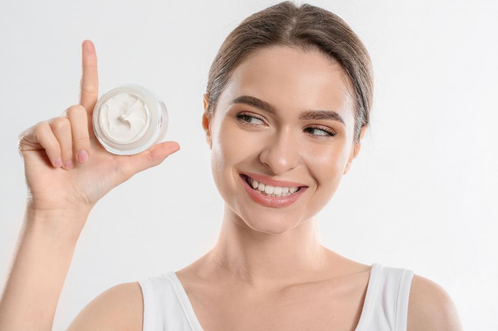 Free Image of A woman holding a jar of cream 