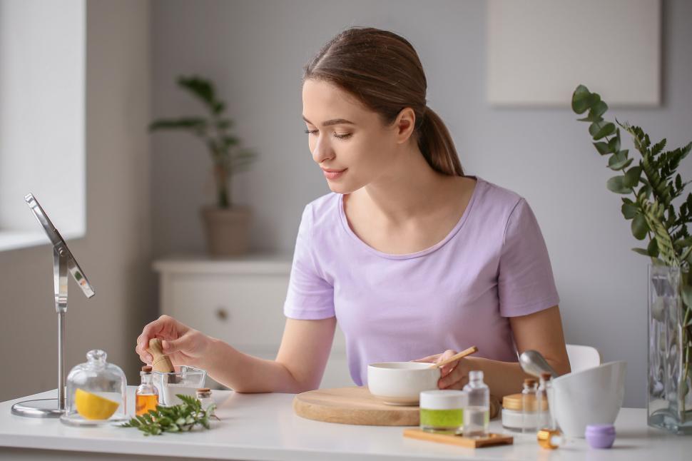 Free Image of A woman sitting at a table with a bowl and a bowl of essential oil 