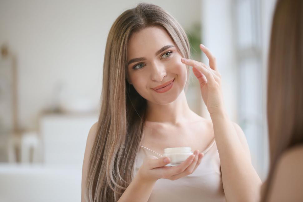 Free Image of A woman holding a jar of cream 