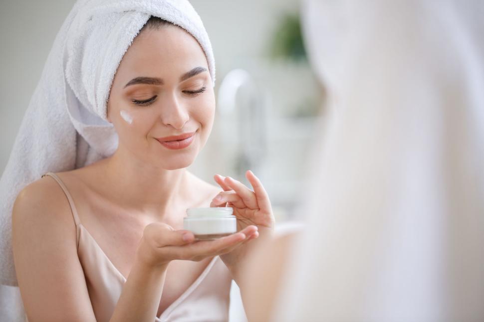 Free Image of A woman applying cream on her face 
