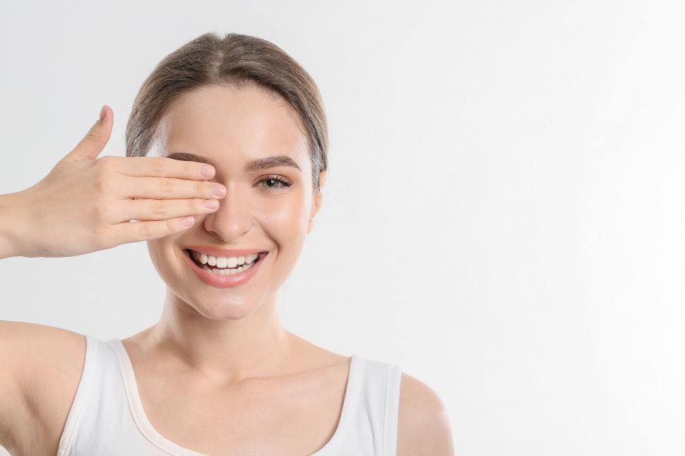 Free Image of A woman covering her eye with her hand 